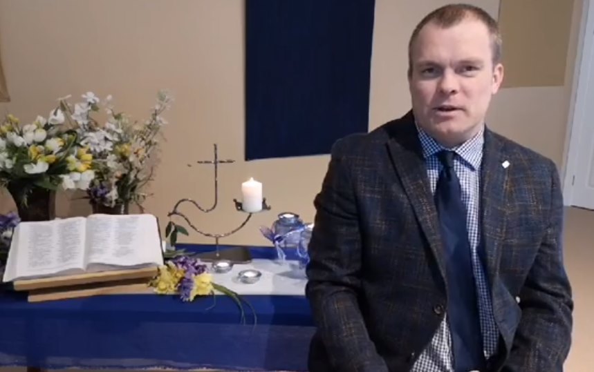 The dove candle appears in Trinity Mennonite Church's online service, displayed behind Pastor William Loewen. Submitted by Tim Wiebe-Neufeld